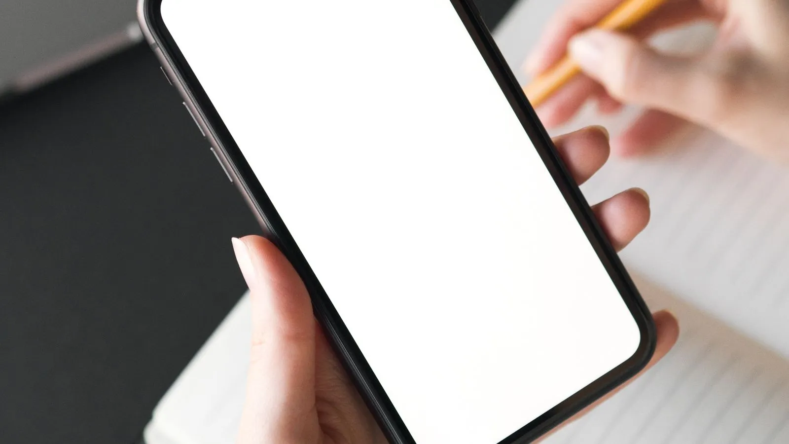 Phone on a desk beside a storage-full notification, with apps and settings in the background